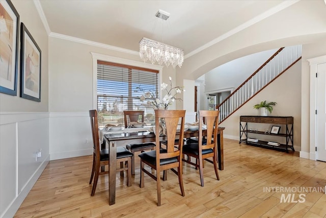25374 W Deep Canyon Dr, Star, ID 83644 - dining space with a chandelier, crown molding, arched walkways, light wood-style floors, and baseboards