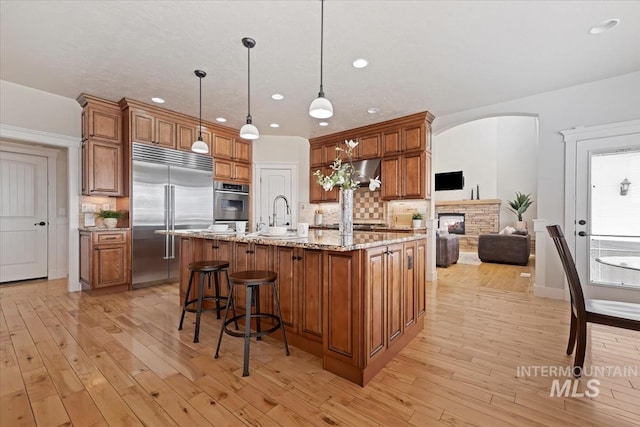 25374 W Deep Canyon Dr, Star, ID 83644 - kitchen featuring stainless steel appliances, recessed lighting, brown cabinetry, a sink, and tasteful backsplash