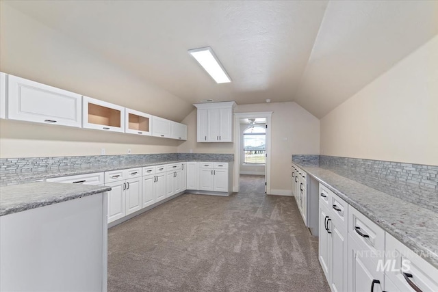 25374 W Deep Canyon Dr, Star, ID 83644 - kitchen featuring light colored carpet, vaulted ceiling, white cabinetry, glass insert cabinets, and light stone countertops