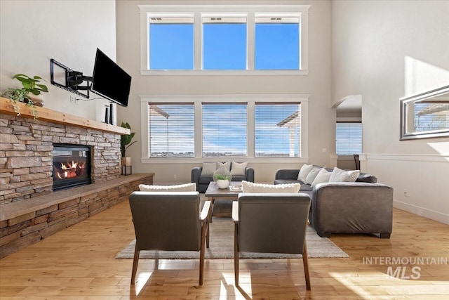 25374 W Deep Canyon Dr, Star, ID 83644 - living area featuring a towering ceiling, arched walkways, a stone fireplace, wood finished floors, and baseboards