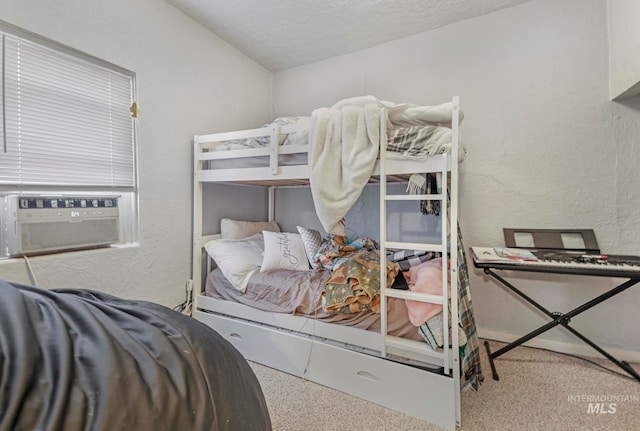 carpeted bedroom featuring a textured ceiling and cooling unit