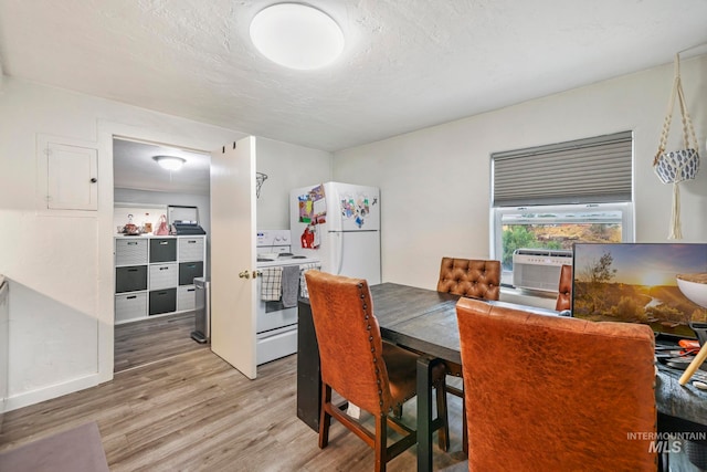 dining space featuring a textured ceiling, wood-type flooring, and cooling unit