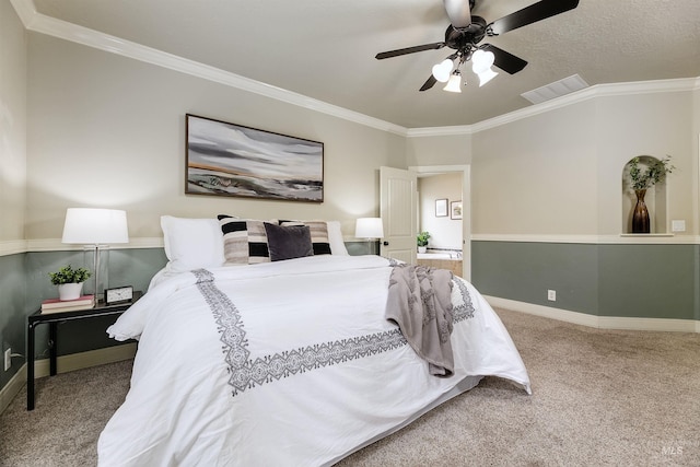 bedroom featuring baseboards, crown molding, visible vents, and carpet flooring