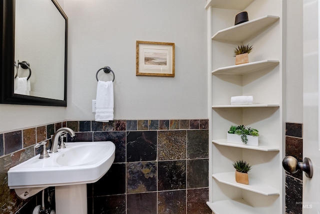 bathroom featuring a sink and tile walls