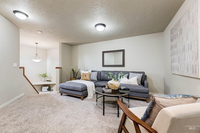 carpeted living area with baseboards and a textured ceiling