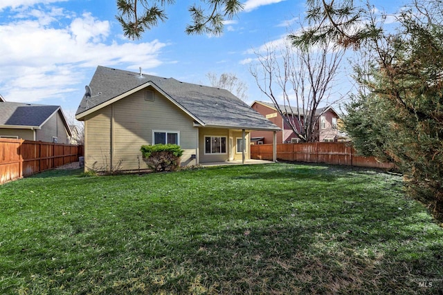 back of property with a yard, a patio area, and a fenced backyard