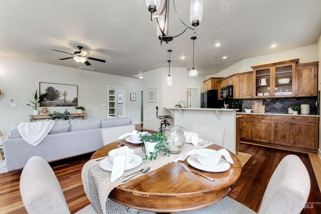 dining space with recessed lighting, a textured ceiling, dark wood-type flooring, and ceiling fan with notable chandelier