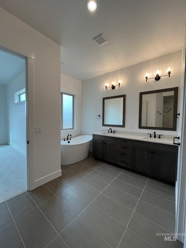 full bathroom with tile patterned flooring, double vanity, visible vents, and a sink