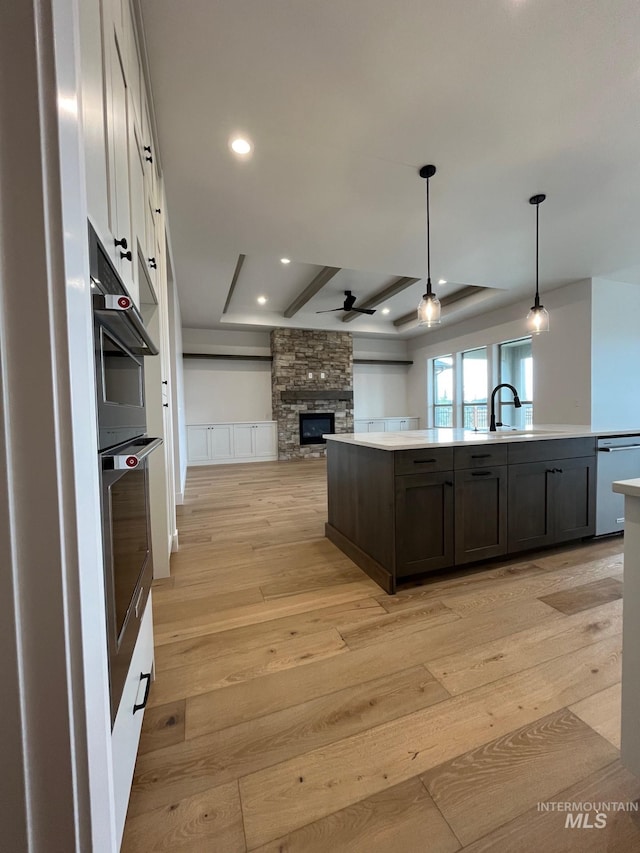 kitchen featuring open floor plan, light wood-style flooring, stainless steel appliances, and light countertops