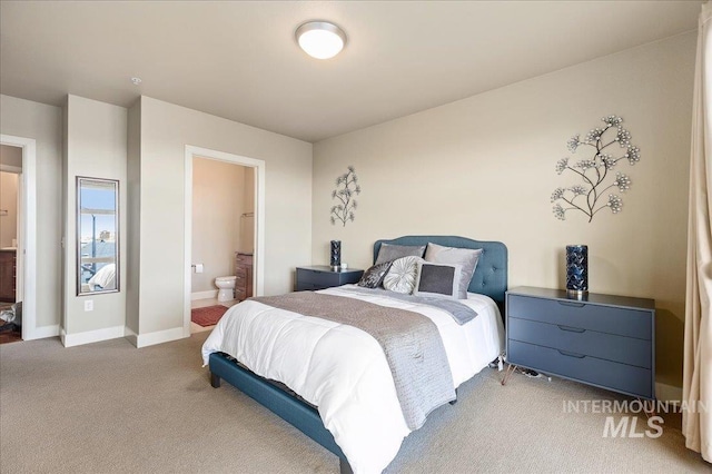 bedroom with light colored carpet and ensuite bath