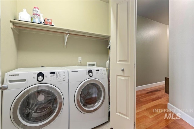 laundry room featuring washer and dryer and light hardwood / wood-style floors