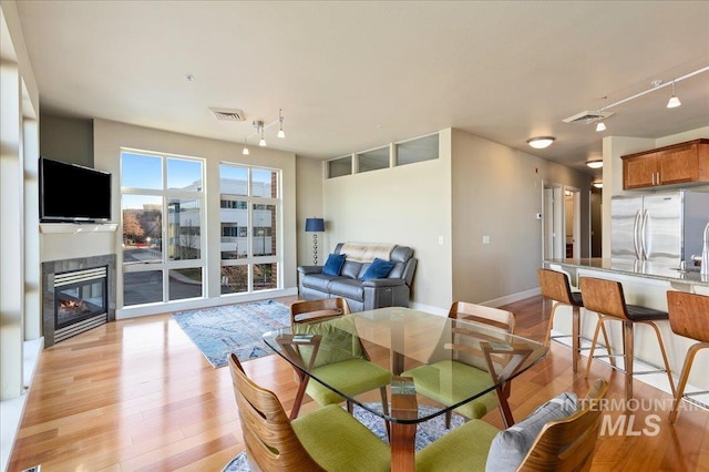 dining room with rail lighting and light hardwood / wood-style floors