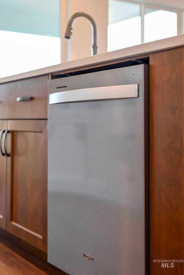 interior details featuring dishwasher, light countertops, and dark wood-style floors