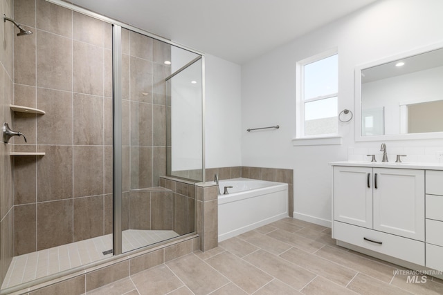 bathroom with recessed lighting, a stall shower, vanity, and a bath