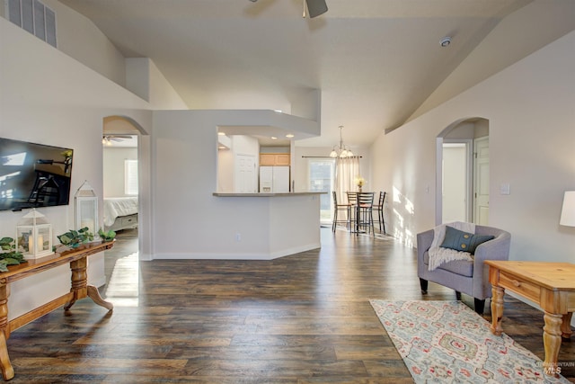 living room with dark hardwood / wood-style flooring and ceiling fan with notable chandelier