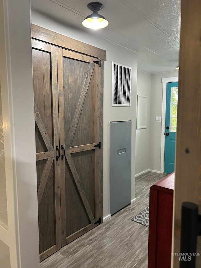 1614 E 1800 S, Gooding, ID 83330 - interior space with wood finished floors, baseboards, a barn door, and a heating unit