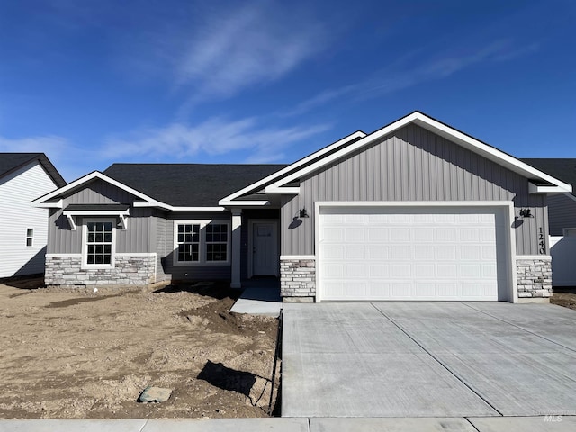 view of front of house featuring a garage, stone siding, and board and batten siding