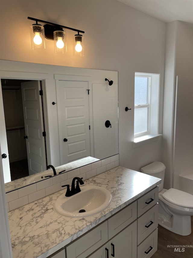 full bath featuring toilet, a shower, and vanity