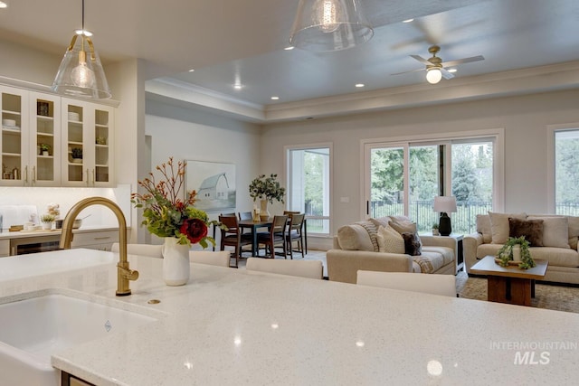 4014 W Farm View Dr, Boise, ID 83714 - kitchen featuring a sink, healthy amount of natural light, light stone countertops, hanging light fixtures, and crown molding