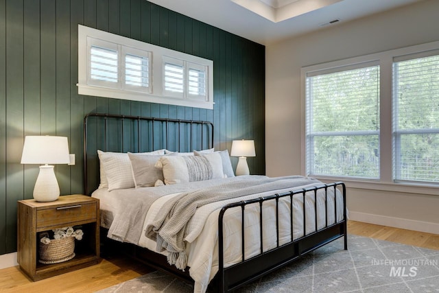 4014 W Farm View Dr, Boise, ID 83714 - bedroom featuring multiple windows, wood finished floors, an accent wall, and baseboards