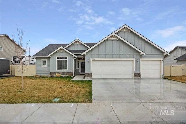 craftsman house with a front lawn, an attached garage, stone siding, and board and batten siding