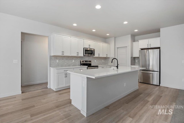 kitchen featuring white cabinetry, light wood-style floors, and appliances with stainless steel finishes