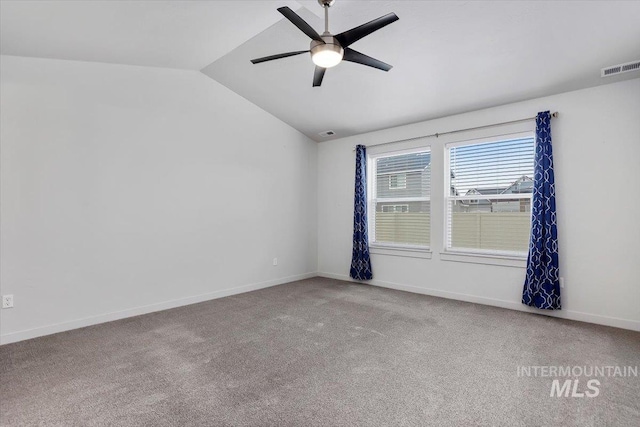 carpeted spare room featuring baseboards, visible vents, vaulted ceiling, and a ceiling fan