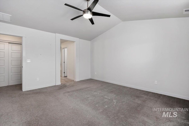 unfurnished bedroom with baseboards, visible vents, vaulted ceiling, and carpet