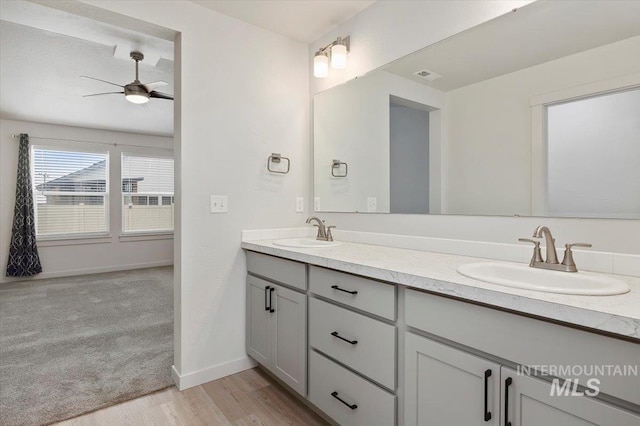 bathroom featuring double vanity, a sink, ceiling fan, and visible vents