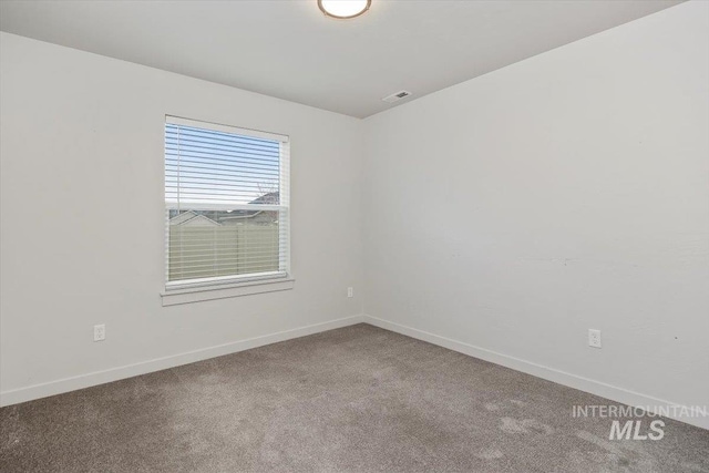 carpeted empty room featuring baseboards and visible vents