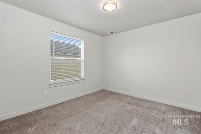 carpeted empty room with baseboards and visible vents