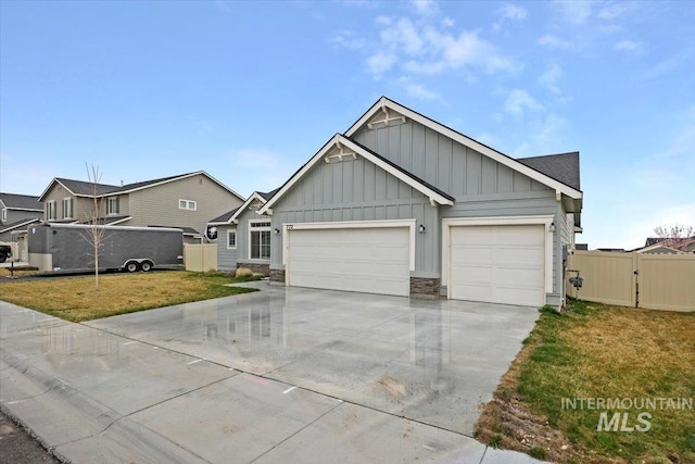 view of front of property featuring stone siding, an attached garage, concrete driveway, a front yard, and board and batten siding