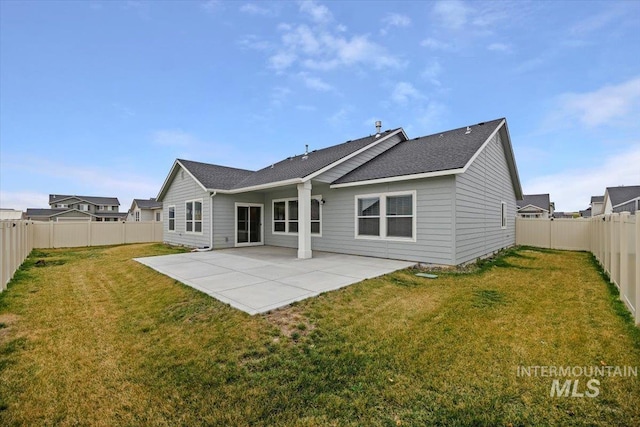 rear view of property featuring a fenced backyard, a yard, and a patio