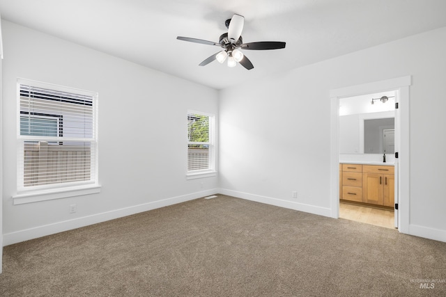 875 N 14th St, Payette, ID 83661 - unfurnished bedroom featuring light carpet, baseboards, connected bathroom, and a ceiling fan