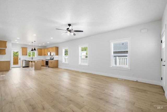 875 N 14th St, Payette, ID 83661 - unfurnished living room featuring baseboards, a ceiling fan, recessed lighting, light wood finished floors, and a sink