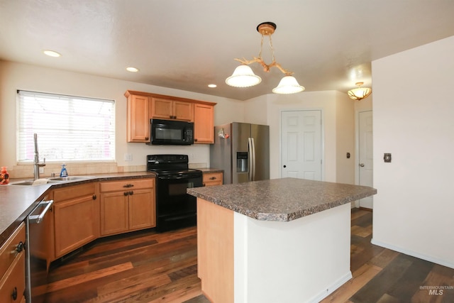 2059 Spring Creek Dr, Fruitland, ID 83619 - kitchen featuring dark wood finished floors, black appliances, a kitchen island, a sink, and decorative light fixtures