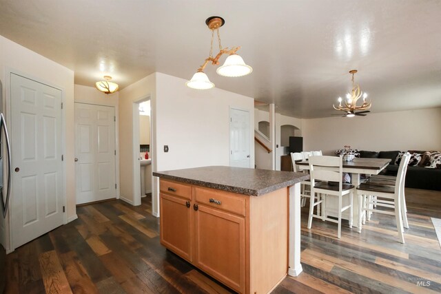 2059 Spring Creek Dr, Fruitland, ID 83619 - kitchen with a chandelier, open floor plan, dark countertops, dark wood-type flooring, and arched walkways