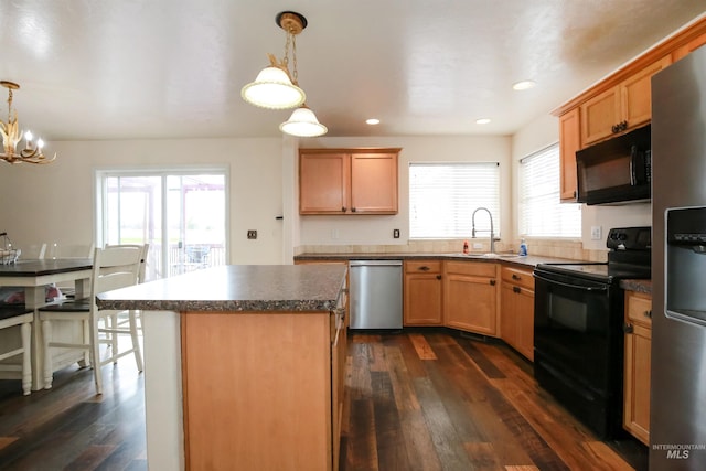 2059 Spring Creek Dr, Fruitland, ID 83619 - kitchen with dark countertops, black appliances, decorative light fixtures, dark wood finished floors, and a sink