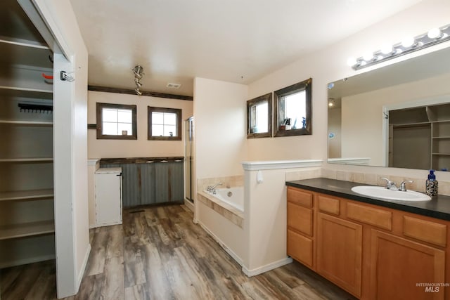 2059 Spring Creek Dr, Fruitland, ID 83619 - full bath featuring vanity, a bath, a stall shower, and wood finished floors
