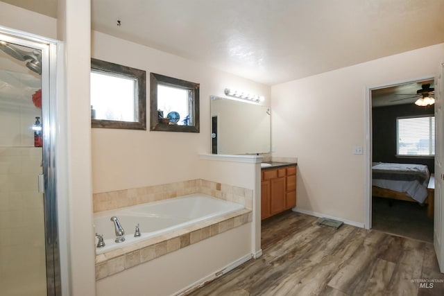 2059 Spring Creek Dr, Fruitland, ID 83619 - ensuite bathroom featuring vanity, ensuite bathroom, a bath, ceiling fan, and wood finished floors