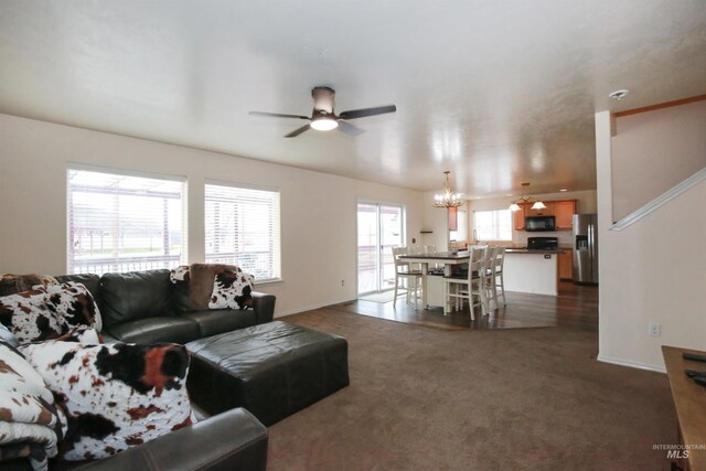 2059 Spring Creek Dr, Fruitland, ID 83619 - living room featuring dark carpet, ceiling fan with notable chandelier, and baseboards