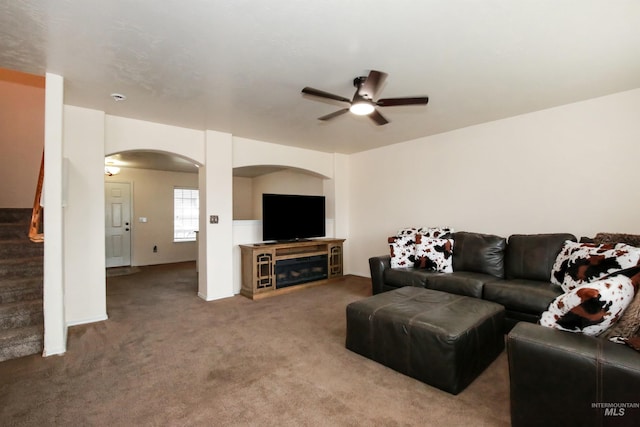 2059 Spring Creek Dr, Fruitland, ID 83619 - living room with arched walkways, stairway, a ceiling fan, and carpet floors
