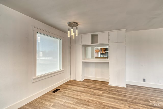 unfurnished dining area with light wood-type flooring