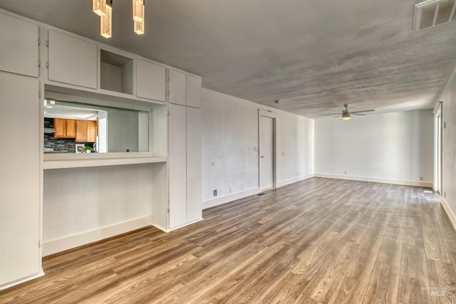 unfurnished living room with ceiling fan and wood-type flooring