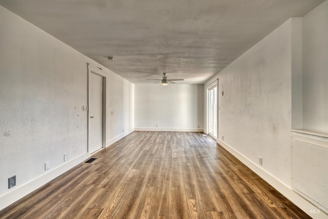 spare room featuring ceiling fan and dark wood-type flooring