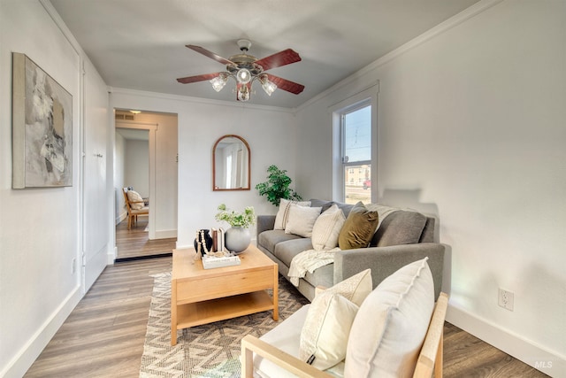 living room with hardwood / wood-style flooring, ceiling fan, and ornamental molding