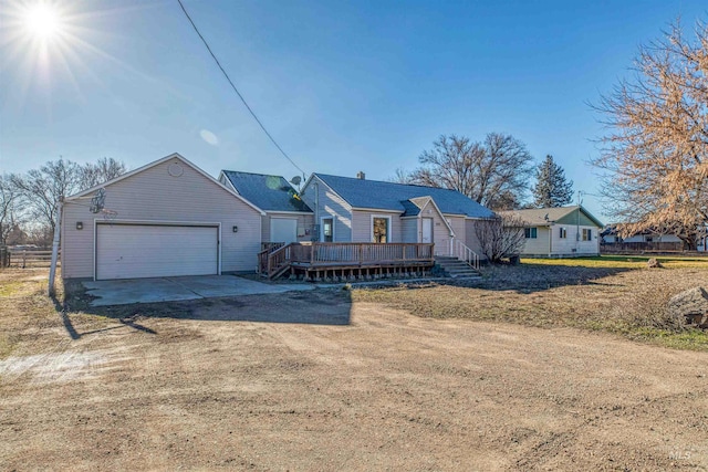 view of front of home featuring a front yard, a garage, and a wooden deck