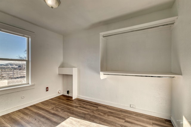 clothes washing area featuring plenty of natural light and dark wood-type flooring