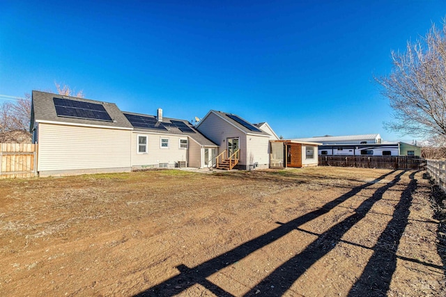 rear view of property with solar panels