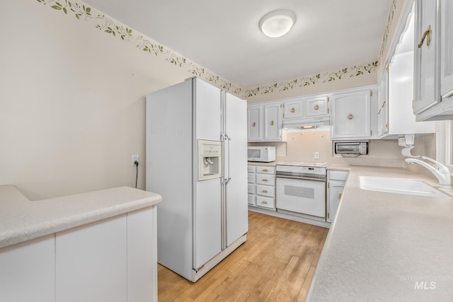 1245 SW 3rd Ave, Ontario, OR 97914 - kitchen with white appliances, a sink, under cabinet range hood, light countertops, and light wood-style flooring
